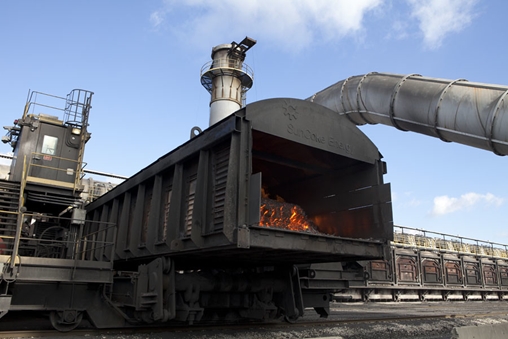 Train with flames and smoke billowing from the rear of the locomotive