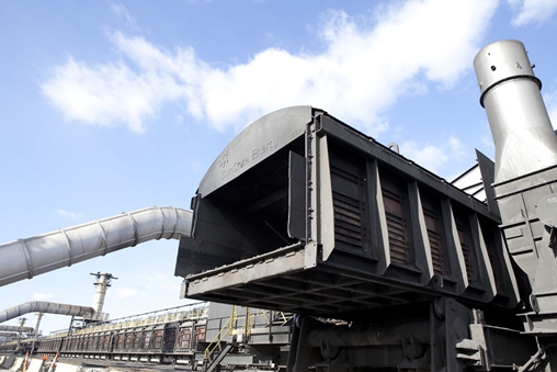 Train with a large pipe, emitting smoke, on a railway track