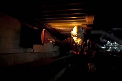 Man wearing a hard hat and a mask for safety at a construction site