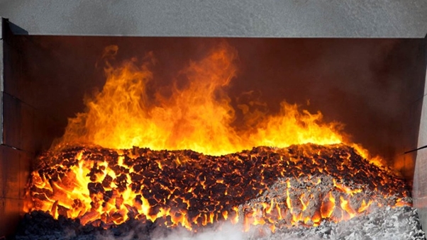 Roaring fire burns in a metal furnace