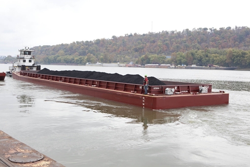 Coal-laden boat sails on the water