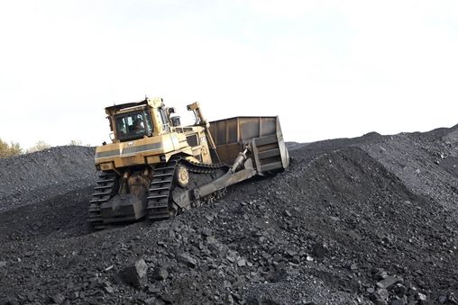 Bulldozer moving through coal pile